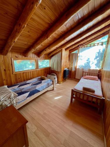 a bedroom with two beds in a wooden cabin at Cielo Azul 4 in Villa Pehuenia