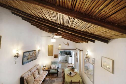 a living room filled with furniture and a wooden ceiling at Casa Delfim - Casas Azul&Verde in Alte