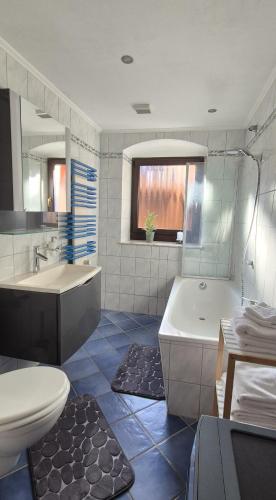 a bathroom with a tub and a sink and a toilet at Ferienwohnung am Töpferberg in Löbau