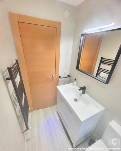 a bathroom with a white sink and a wooden door at Carbonería 4 in Soria