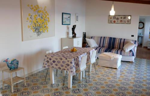 a living room with a table and a couch at Casa Paradiso - Panoramic Sea View & Jacuzzi in Terracina