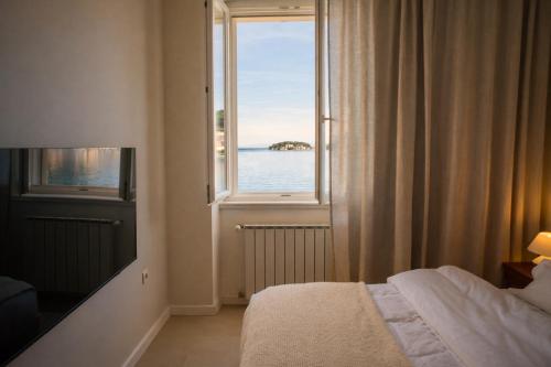 a bedroom with a window with a view of the water at The Wave Seafront Apartment Vis in Vis