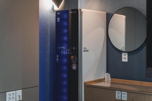 a bathroom with a mirror and a blue wall at Hotel ONYU Busan Sasang in Busan