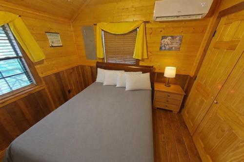 a small bedroom with a bed in a cabin at MeMaws Country Cabin in Pipe Creek
