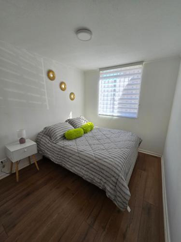 a bedroom with a bed with green pillows and a window at Céntrico y cómodo departamento in Los Andes