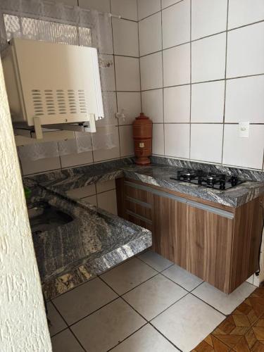 a kitchen with a stove and a counter top at Pousada Popular in Três Marias