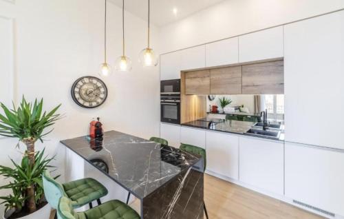 a kitchen with a glass table and green chairs at MONTE CARLO BORDER - exclusive & modern flat in Beausoleil