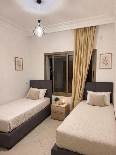 a bedroom with two beds and a window at Asilah Ocean View Residence in Asilah