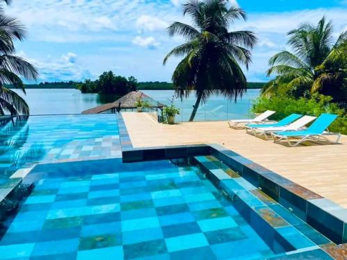 a resort swimming pool with a view of the water at villa rach in Assinie