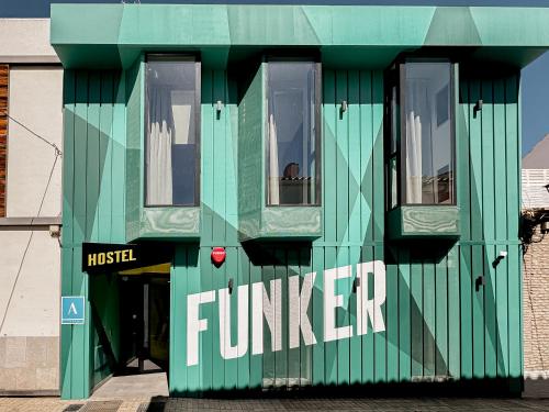 a green building with the word fundraiser written on it at Funker Hostel in Málaga