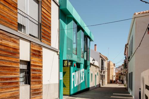 a building with a green door on a street at Funker Hostel in Málaga