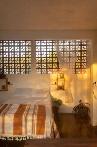 a bedroom with a bed and two large windows at Oceanfront, AC and Parking, La Punta in Paso Hondo