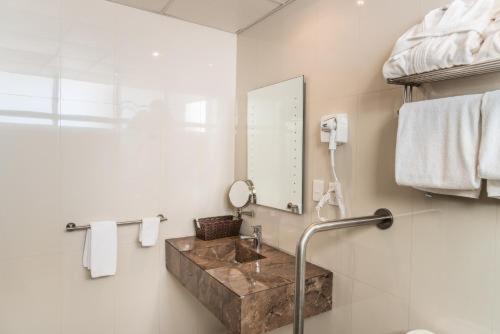 a bathroom with a sink and a mirror at Hotel Grand Elizabeth in Durango