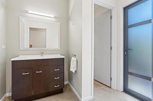 a bathroom with a sink and a mirror at Relaxed Getaway in Mangawhai