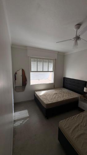 a bedroom with two beds and a window at Apê Completo - 300m da Praia in Guarujá