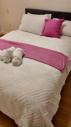 a large bed with two towels on top of it at Central Luxe in Surrey