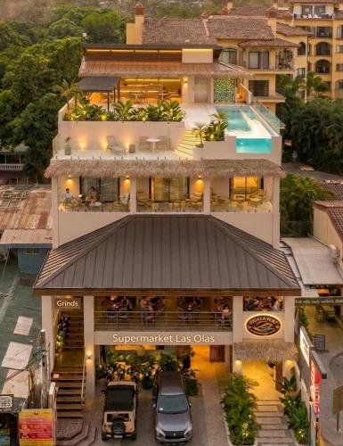 an apartment building with a restaurant in front of it at Iguana Surf Boutique Hotel Tamarindo Rooftop Pool & Beachfront Suites in Tamarindo