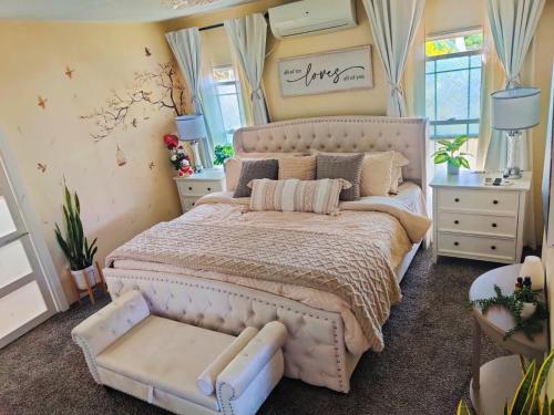 a bedroom with a large bed and a chair at Cozy Stays in Oranjestad