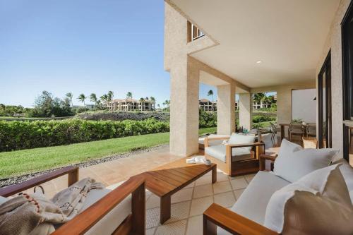 a patio with couches and a view of a house at New Sunset Villa Ocean Side Lanai Pool Kings in Waikoloa