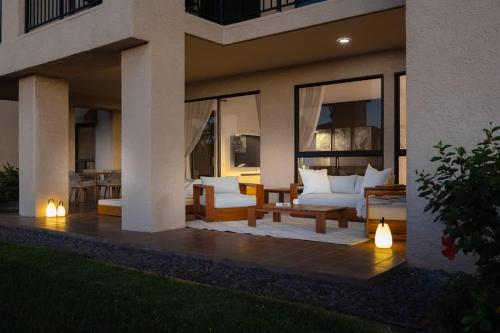a patio with white couches and tables on a house at New Sunset Villa Ocean Side Lanai Pool Kings in Waikoloa