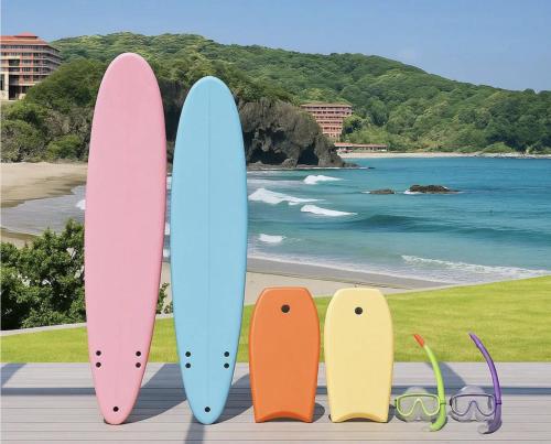 four surfboards are lined up on the beach at Aquaholic Iritahama in Shimoda