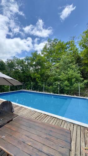 a blue swimming pool on a wooden deck at Espaço Move in Porto Seguro