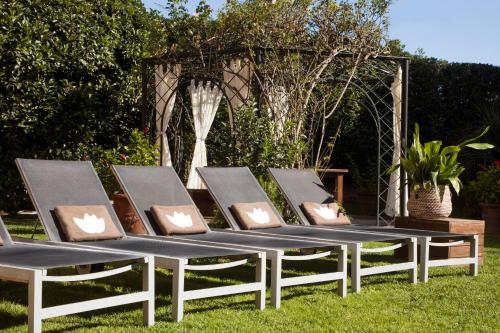 a group of lounge chairs sitting on the grass at Luna Park Hotel Yoga & Spa in Malgrat de Mar