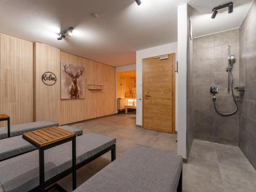 a bathroom with a shower and a bench and a toilet at Tauernlodge Wagrain Edelweiss 42E in Wagrain