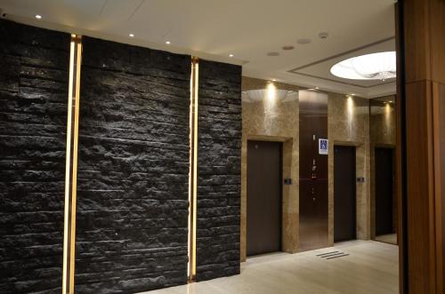 a lobby with a black stone wall at Green World Grand NanJing in Taipei