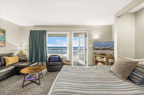 a living room with a bed and a couch at Oceanfront Family Suite - Full Kitchen - Beautiful Views and Pool & Hot Tub Access in Lincoln City