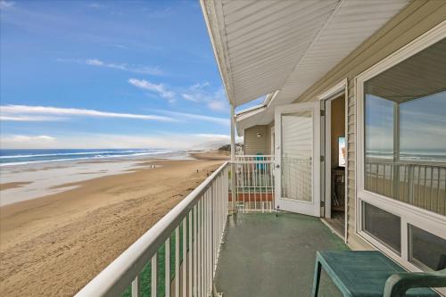 a balcony of a house with a view of the beach at Oceanfront Family Suite - Full Kitchen - Beautiful Views and Pool & Hot Tub Access in Lincoln City