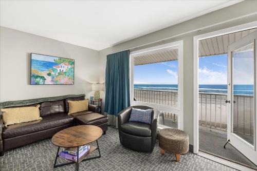 a living room with a couch and a table at Oceanfront Family Suite - Full Kitchen - Beautiful Views and Pool & Hot Tub Access in Lincoln City