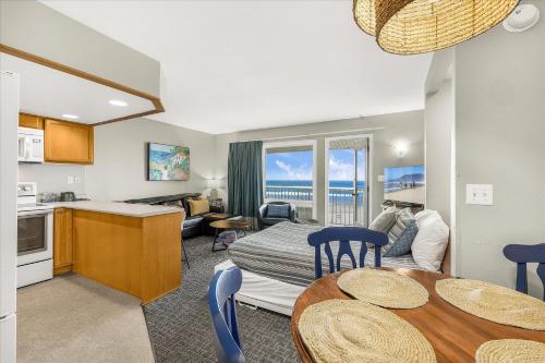 a kitchen and a living room with a bed and a table at Oceanfront Family Suite - Full Kitchen - Beautiful Views and Pool & Hot Tub Access in Lincoln City