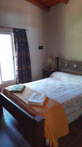 a bedroom with a large bed and a window at Cabaña LA SOÑADA in Villa Anizacate
