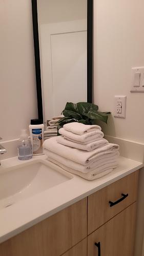a pile of towels sitting on a counter in a bathroom at Modern Suite Near Hamilton Airport in Hamilton