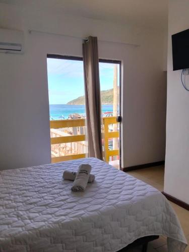 a bedroom with a bed with a view of the ocean at Pousada Thetis in Arraial do Cabo