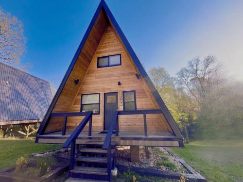 a small house with a gambrel roof with a staircase at Black Gum Getaway-Cozy Forest A-frame Near Bentonville in Rogers