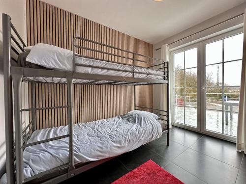 a bedroom with two bunk beds and a window at Le Congo in Ochamps