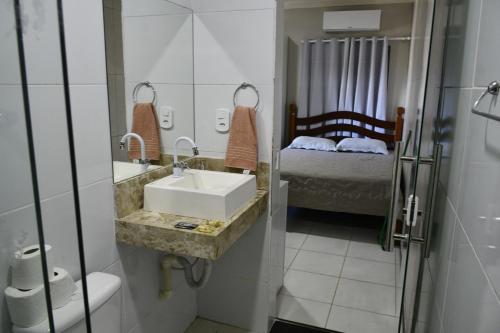 a bathroom with a sink and a bed at Pousada Bem-te-vi in Aracaju