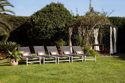 a group of chairs sitting on the grass at Luna Park Hotel Yoga & Spa in Malgrat de Mar