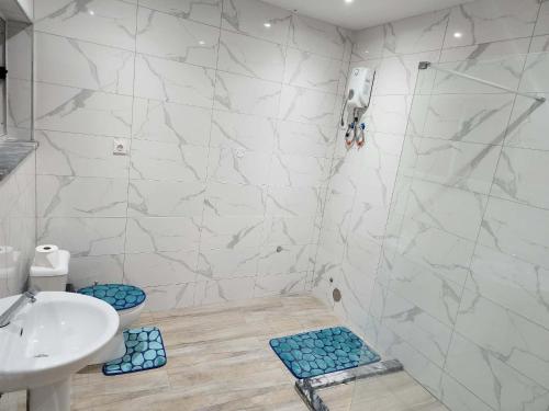 a bathroom with a shower and a sink and a toilet at Soares Stay in Tarrafal
