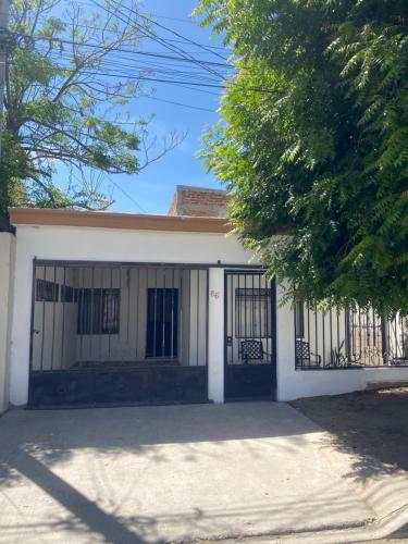 a white house with a gate and a driveway at Casa Olivos in Hermosillo