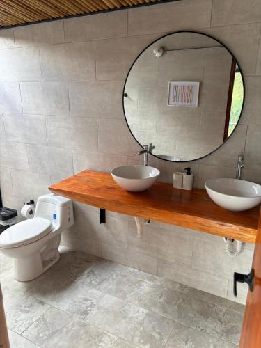 a bathroom with a sink and a mirror and a toilet at Cabaña Piamonte Villeta in Villeta