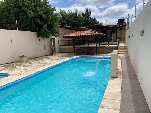 a swimming pool in a backyard with a gazebo at Espaço Victoria in Caruaru