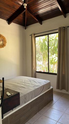 a bedroom with a bed and a large window at Green Point Nosara in Nosara