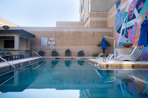 a swimming pool with chairs and a mural on the side of a building at Domain Luxe in Austin