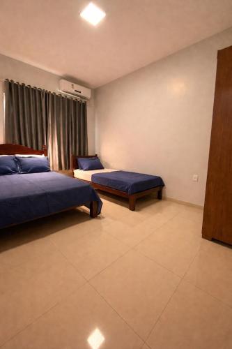 a hotel room with two beds and a window at Casa Aconchego Lar in Rio Verde