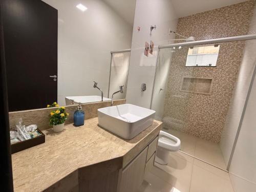 a bathroom with a sink and a toilet at Casa Aconchego Lar in Rio Verde