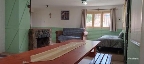 a living room with a table and a fireplace at Casa Nur in Potrerillos