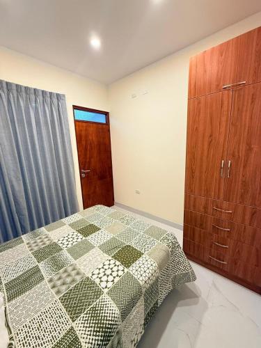 a bedroom with a bed and a wooden cabinet at Refugio del Viajero in Carhuaz